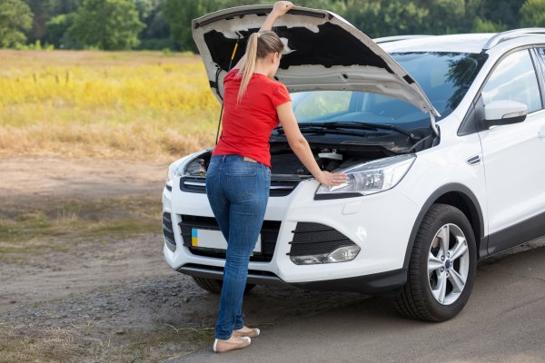 extended car warranty service car car problem white car woman looking under the hood 